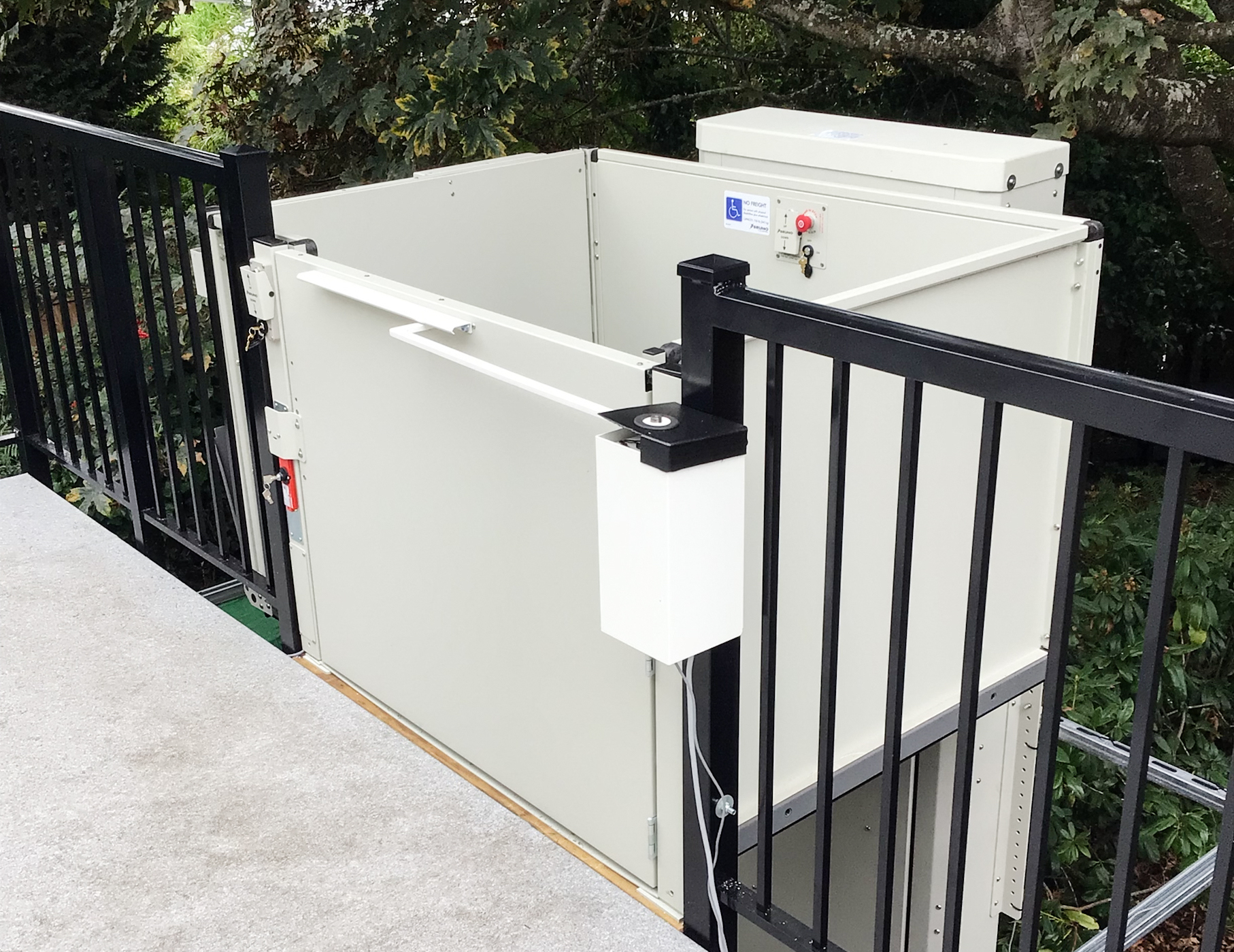 vertical platform lift attached in a black railing