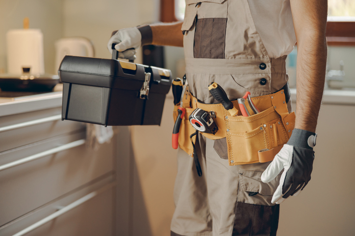 professional handyman standing holding a tool bag