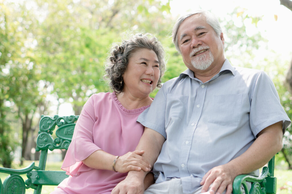 healthy senior couple relaxing seated in the park together